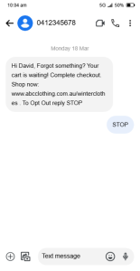 Screenshot of an SMS message on a smartphone. The message is from the number 0412345678 and reads "Hi David, Forgot something? Your cart is waiting! Complete checkout. Shop now: www.abcclothing.com.au/winterclothes . To Opt Out reply STOP